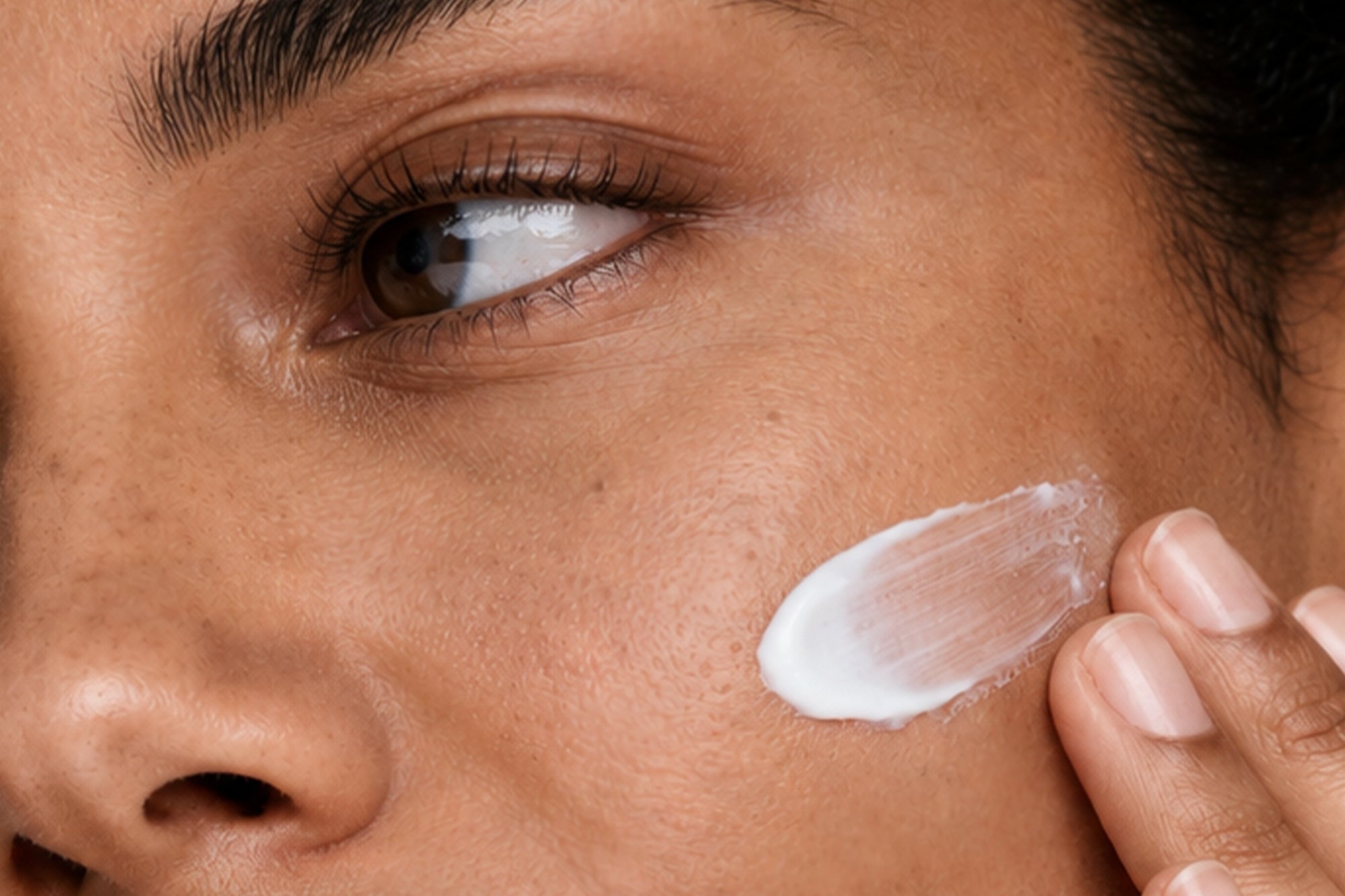 NEOVA - Best Sellers - Mega Menu - Close-up of a person applying skin care cream to their face