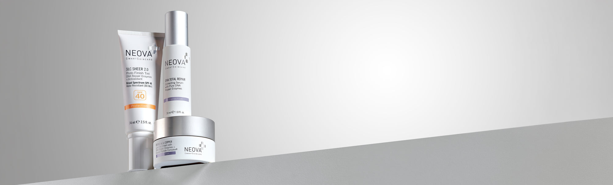 NEOVA - Our Story - Three best-selling skin care products on a grey ledge against a clean grey, gradient background.