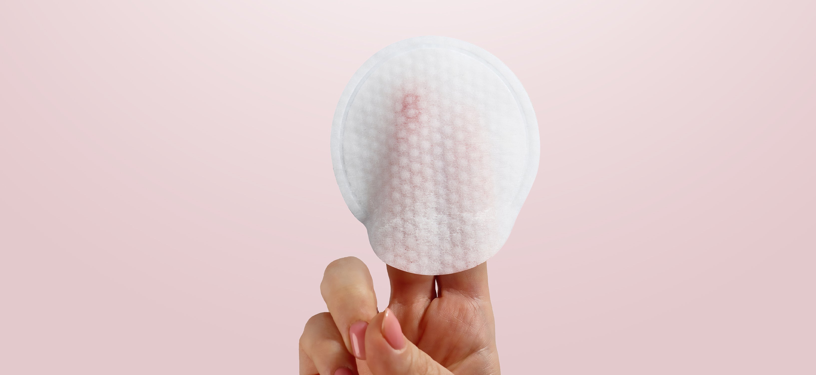 NEOVA - 5-Second Daily Peel - Desktop - A hand holding a round, white, textured cotton pad against a soft pink background.