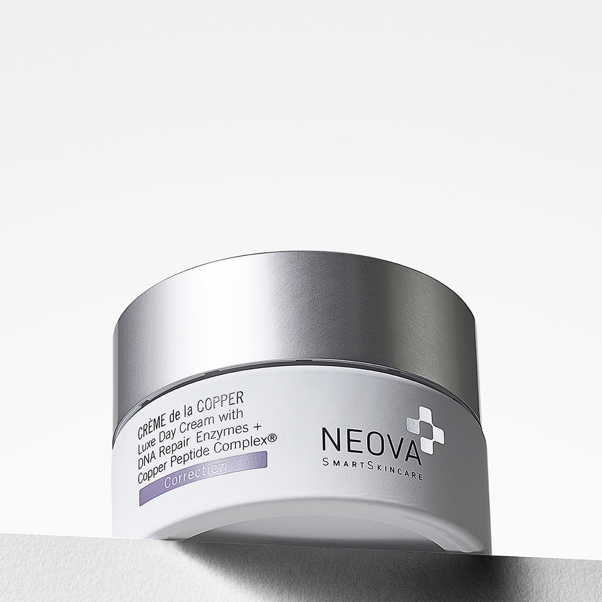 NEOVA Crème de la Copper, a luxe day cream with DNA repair enzymes and Copper Peptide Complex, in a jar with a reflective cap set against a minimalist white backdrop.