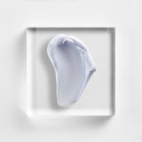 NEOVA Crème de la Copper on a clear acrylic block. The top-down macro view shows off the thick, white consistency of this hydrating facial repair cream.