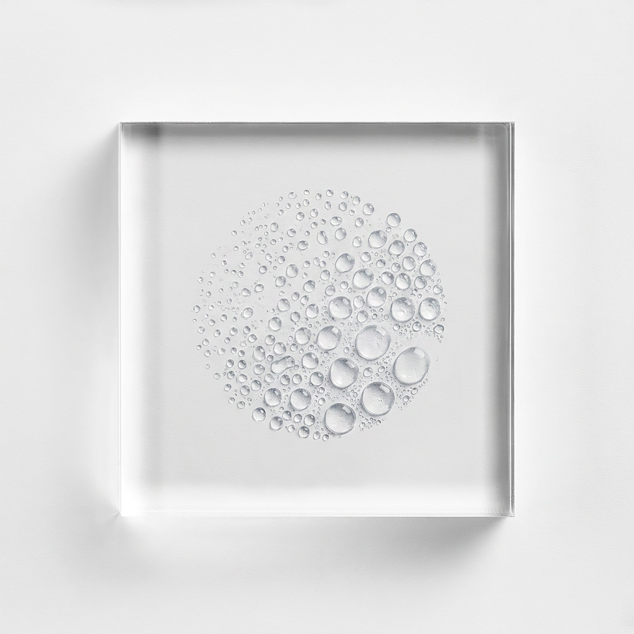 NEOVA Cu3 Recovery Spray texture is presented as clear, spherical water droplets on a transparent glass plaque against a white background, visualizing the lightweight and soothing formula for skin barrier support.