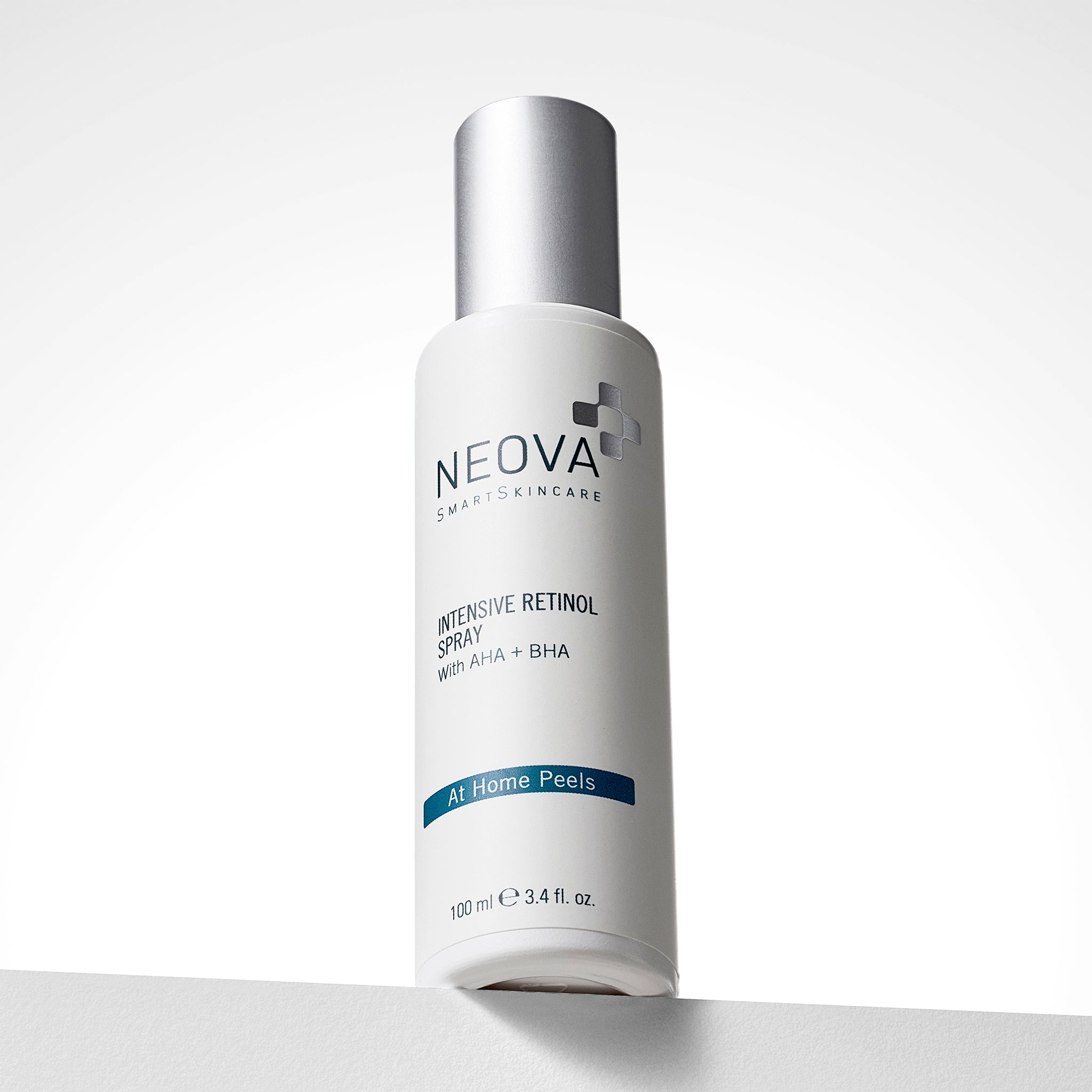 NEOVA Intensive Retinol Spray in a tall, white cylindrical bottle. The front label identifies it as having "AHA + BHA" and categorizes it under a dark blue "At Home Peels" banner. The bottle features a brushed silver cap and contains 3.4 fl. oz. (100 ml), shown standing on a white ledge against a clean, bright background.