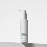 NEOVA Tricomin Fortifying Conditioner 100ml in a white bottle. The label describes notes the hair conditioner "Strengthens Hair at the Root." and is "Formulated with AHK-Cu" to "Nourish", "Repair" and "Restore". The bottle features a white pump top and contains 3.4 fl. oz. (100 ml). It is shown standing on a white surface against a clean, bright minimalist background.