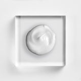 NEOVA Tricomin Fortifying Conditioner texture closeup, highlighting the rich, clinical formula designed to strengthen thinning hair and improve scalp health. This nourishing copper peptide conditioner is shown as a creamy white dollop on a minimalist glass background, emphasizing its professional-grade quality.