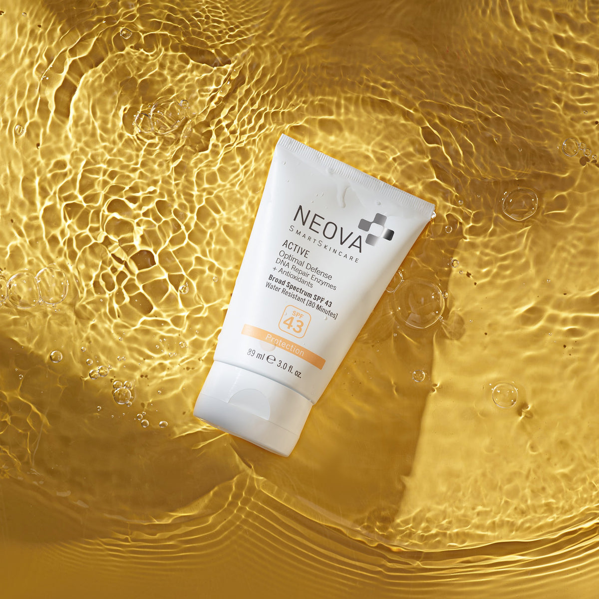 NEOVA - Active - Water-resistant sunscreen tube, a summer skin essential, in water on a sun-yellow background.