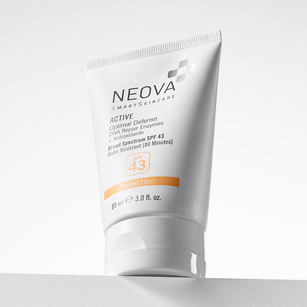 NEOVA Active Broad Spectrum SPF 43 sunscreen in a white squeeze tube. The front label features clean black and orange text highlighting "Optimal Defense," "DNA Repair Enzymes," and "Antioxidants." It notes the formula is water-resistant for 80 minutes and contains 3.0 fl. oz. (89 ml). The tube is angled slightly, resting on a white surface against a minimalist, bright white background.