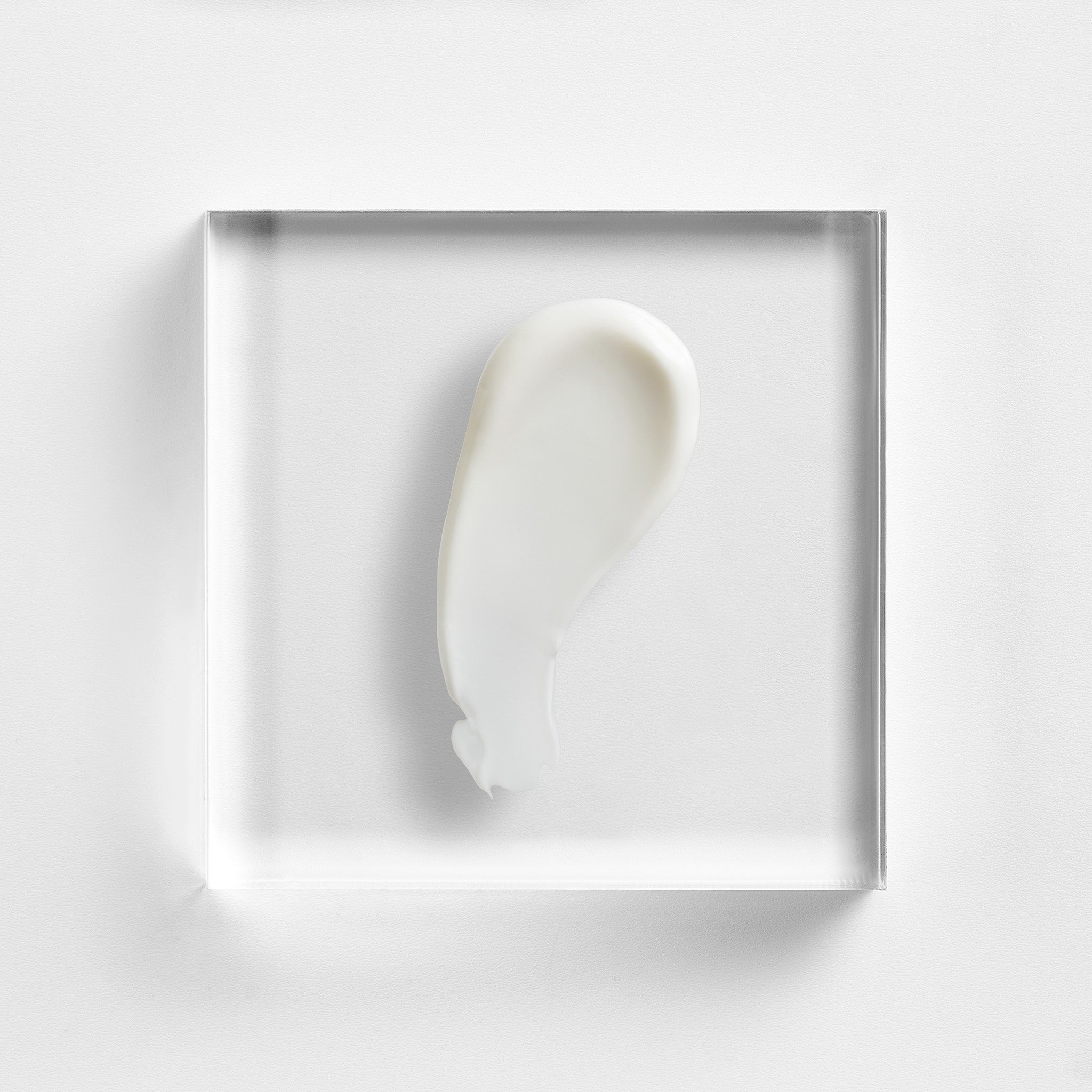 NEOVA Body Repair - texture image: a smooth, off-white serum sample on clear acrylic, highlighting its smooth, nourishing, and hydrating texture.