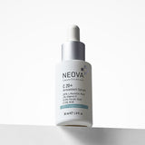 NEOVA SmartSkincare C 20+ Antioxidant Serum in a white dropper bottle. The front label specifies a potent formula of 20% L-Ascorbic Acid, 1% Vitamin E, 0.5% Ferulic Acid, and 0.5% AHA and categorizes it using a blue "Prevention" label. The bottle is topped with a brushed silver collar and a white rubber dropper bulb, sitting on a clean white surface against a bright, minimalist background.