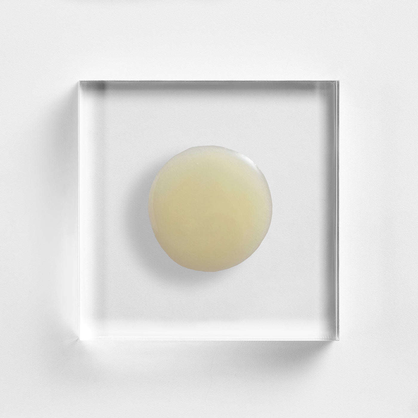 NEOVA Cell Renewal - texture image: a translucent yellow gel disc on clear acrylic, highlighting its smooth, lightweight resurfacing texture.