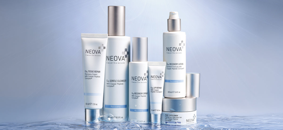 NEOVA - Recovery - Six NEOVA skincare products from the Recovery line in white and silver packaging, arranged on a reflective wet surface against a soft blue gradient background. Products include a recovery cream, a gentle cleanser, a recovery spray, a lip repair balm, a recovery lotion, and a healing recovery gel mask with copper peptides.