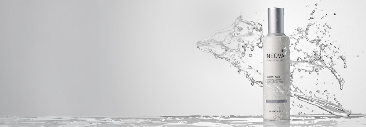 NEOVA - Radiant Wash - A white bottle of NEOVA Radiant Wash  clarifying gel cleanser with a silver cap, standing on a reflective water surface with a dynamic water splash behind it against a light gray background.