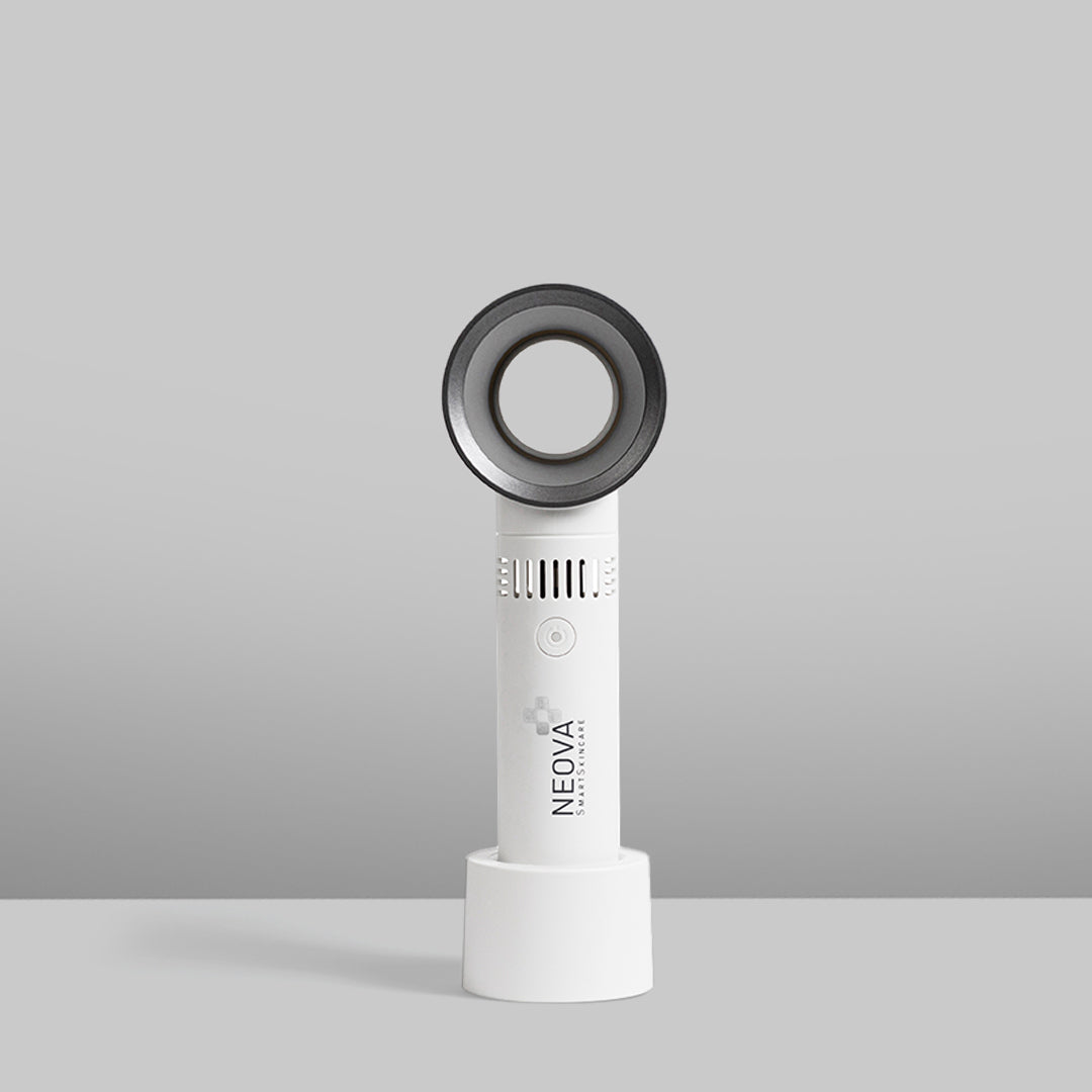 NEOVA - fan - A white and dark gray NEOVA portable fan standing upright on its circular white charging base against a clean gray studio background.