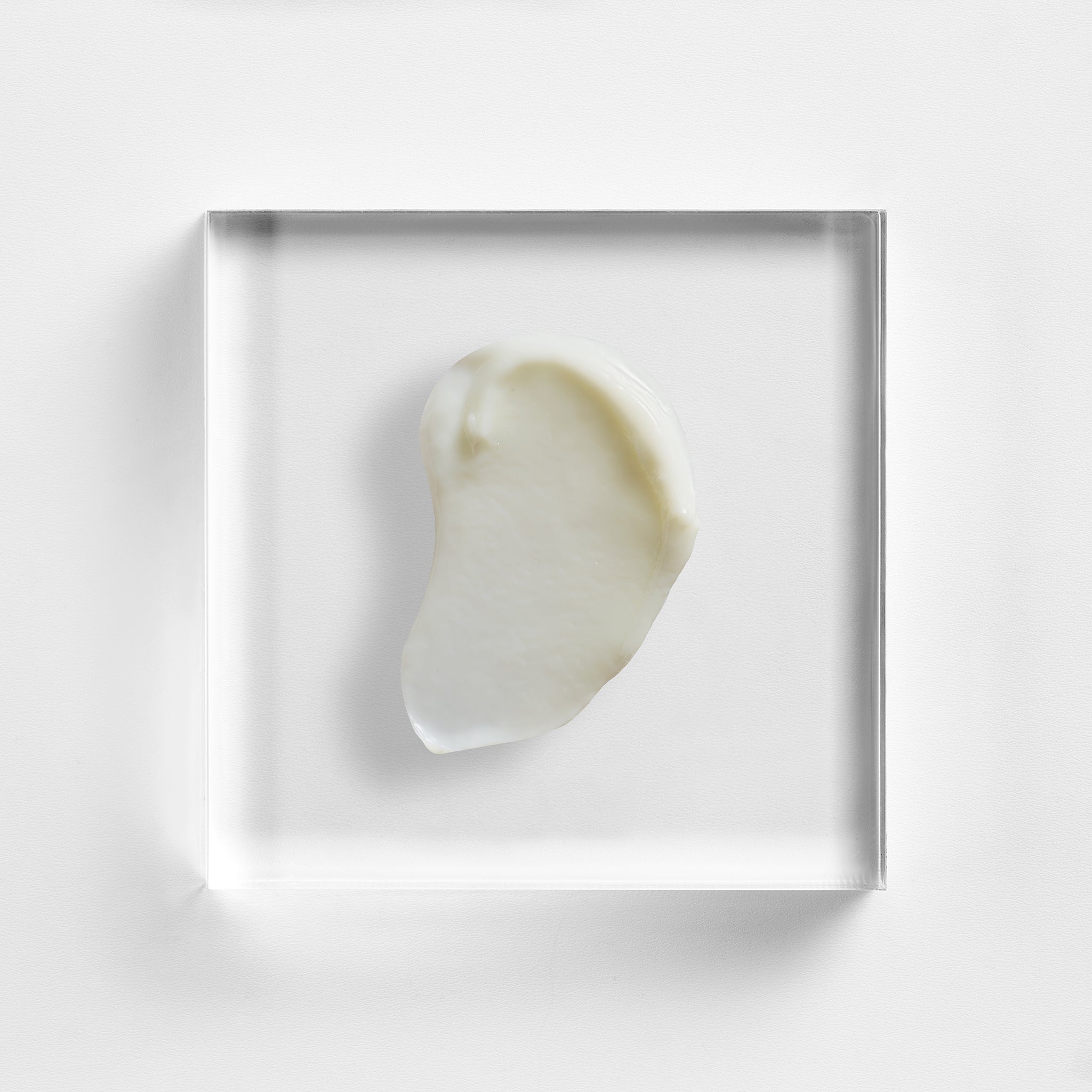 NEOVA Overnight Repair cream on a clear acrylic square. The top-down, macro view shows the thick moisturizing cream is a solid, opaque white with a rich, dense consistency and a smooth, matte finish. It is centered and brightly lit against a minimalist white background, highlighting its nourishing and concentrated formula.