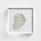 NEOVA Overnight Repair cream on a clear acrylic square. The top-down, macro view shows the thick moisturizing cream is a solid, opaque white with a rich, dense consistency and a smooth, matte finish. It is centered and brightly lit against a minimalist white background, highlighting its nourishing and concentrated formula.