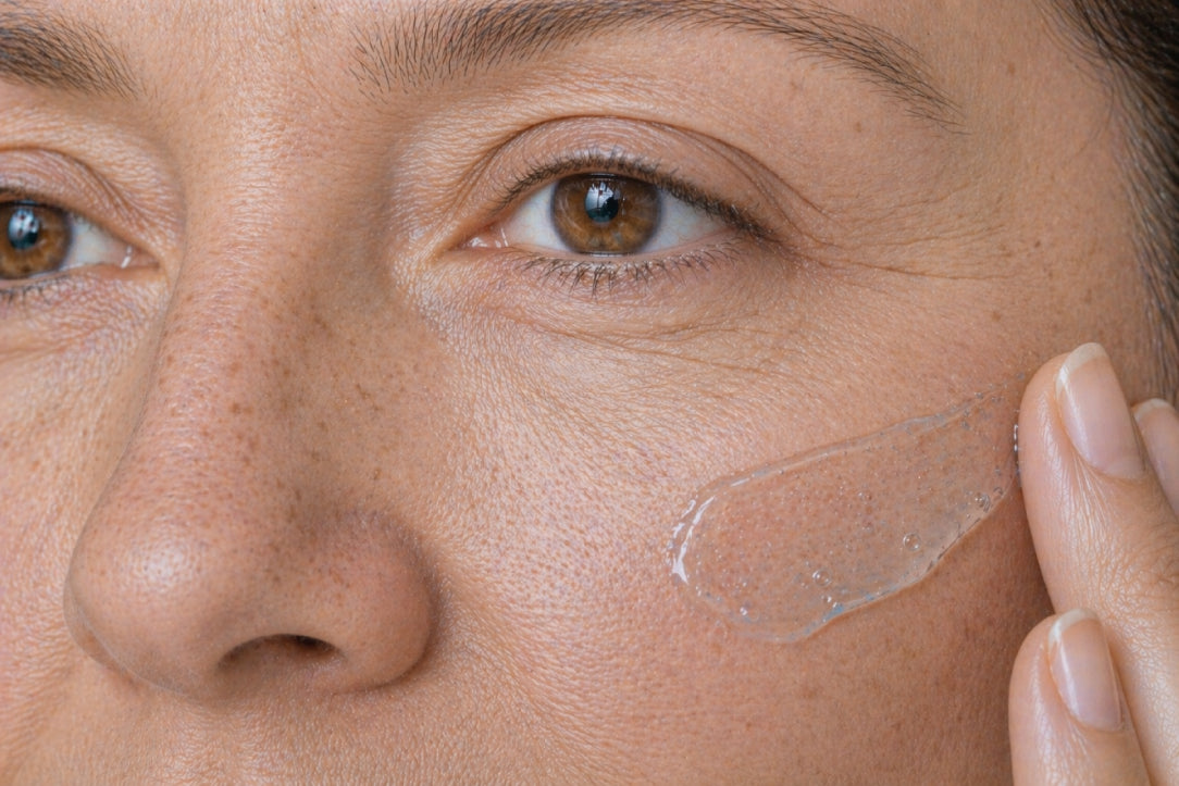 NEOVA Power Defense – application: Close-up of cheek showing protective day cream being applied to defend against UV damage, reduce signs of photodamage, and improve skin resilience.