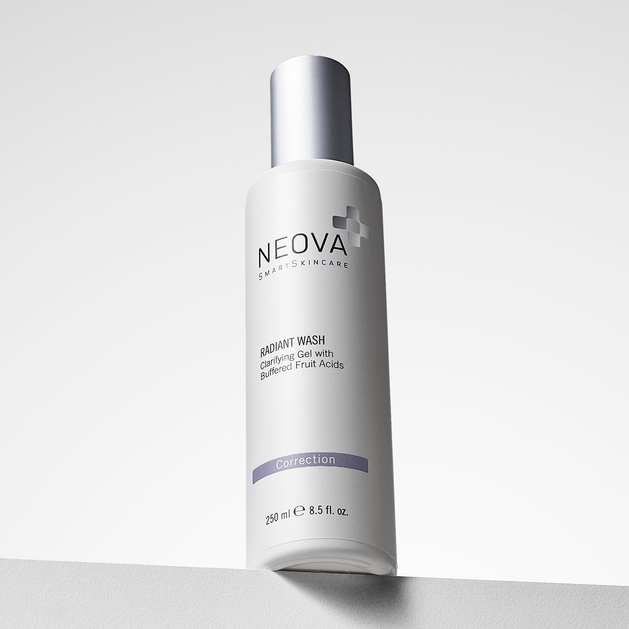 NEOVA Radiant Wash in a tall, white cylindrical bottle. The front label identifies it as a "Clarifying Gel with Buffered Fruit Acids", categorizing it under a purple "Correction" banner. The bottle features a brushed silver cap and contains 8.5 fl. oz. (250 ml), shown standing on a white ledge against a clean, bright minimalist background.