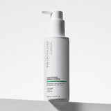 NEOVA Tricomin Fortifying Conditioner in a white bottle. The label describes notes the hair conditioner "Strengthens Hair at the Root." and is "Formulated with AHK-Cu" to "Nourish", "Repair" and "Restore". The bottle features a brushed white pump top and contains 6.0 fl. oz. (180 ml). It is shown standing on a white surface against a clean, bright minimalist background.