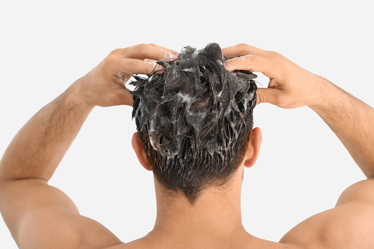 NEOVA Tricomin Fortifying Conditioner  - application image: Person treating their hair with hair conditioner on a plain background